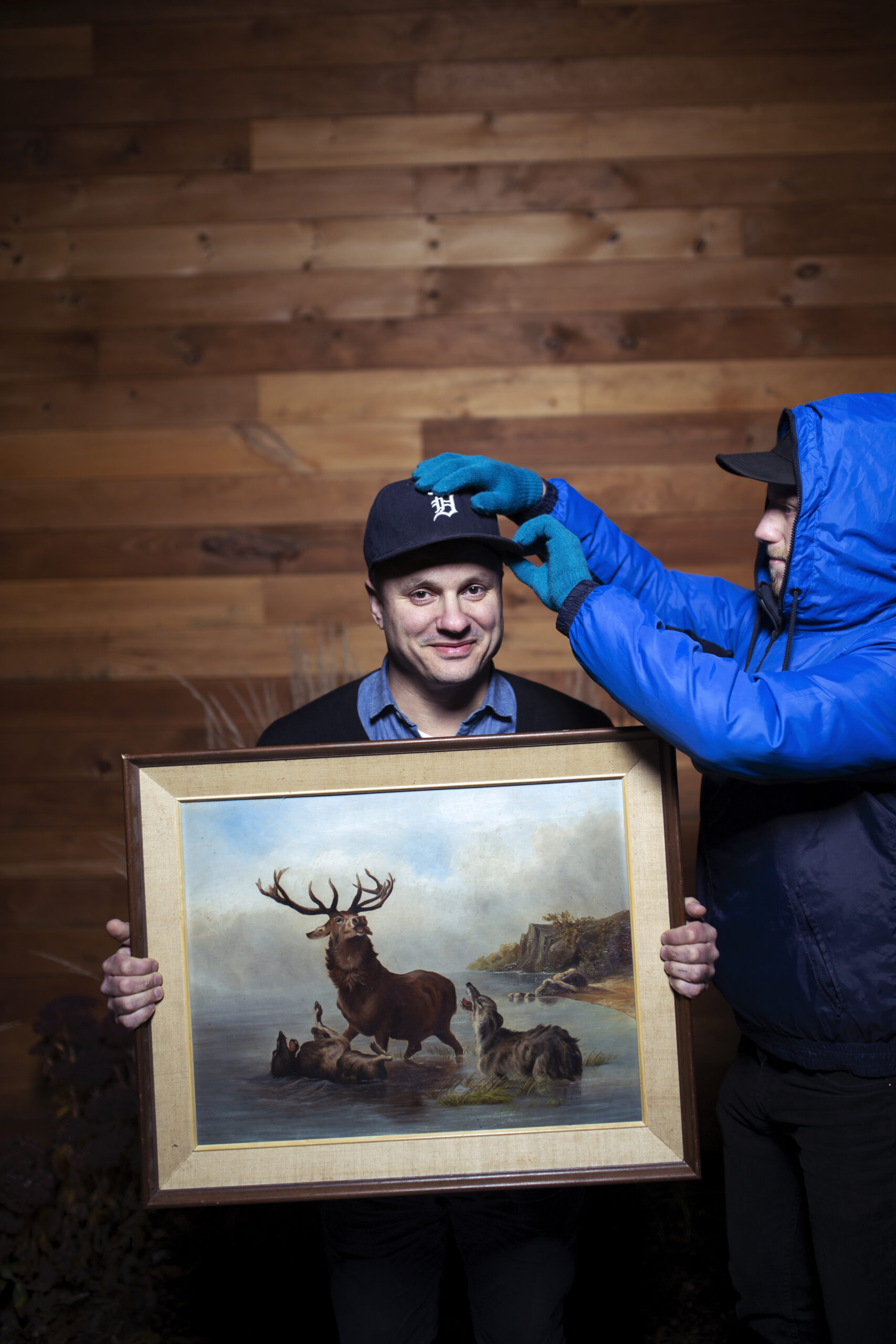 photograph of Jim Bryson wearing ball cap and holding painting