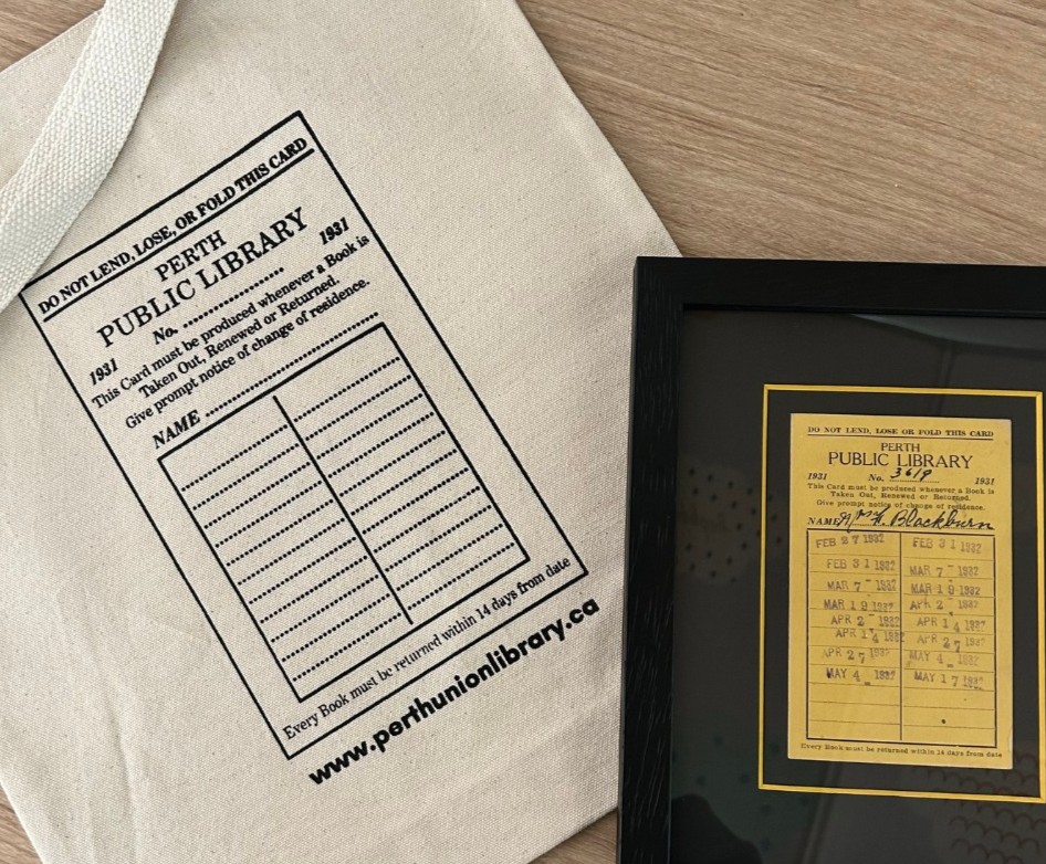 two library staff members display the Perth & District Library's wagon for the 2024 Perth Pride Parade